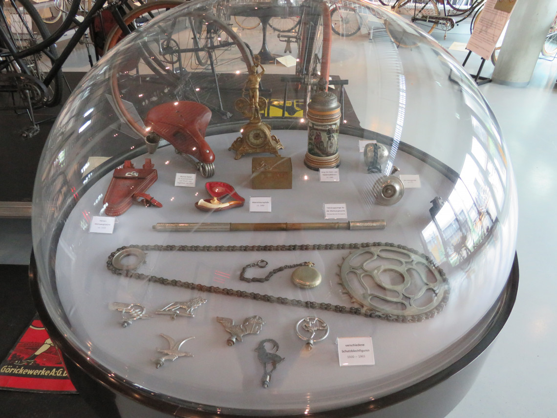 Vitrine mit Fahrradzubehör, Kunstgewerblichen Gegenständen zum Thema Fahrrad und Schutzblechfiguren